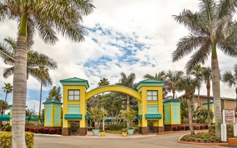 Hotel entrance with yellow & aqua arc surrounded by palm trees