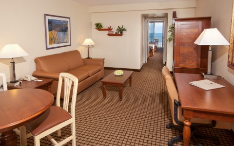 Living space with sofa, coffee table, wooden desk & dining table 