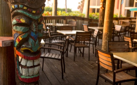 Outdoor dining area with tables chairs & decorative tiki pole