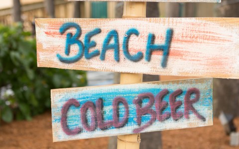 Drift wood reads pina coladas, smores, beach, cold beer & the parrots trail