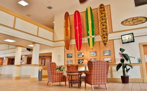 Hotel lobby with seating area & decorative surfboards on wall 